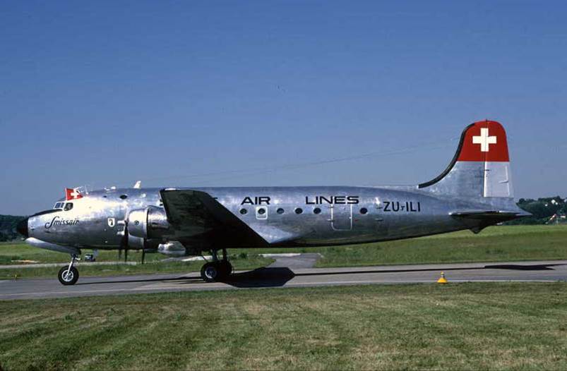 A silver airplane on a runway

Description automatically generated