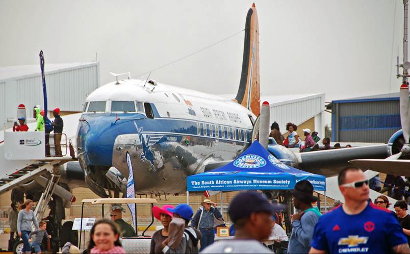 A group of people walking around an airplane

Description automatically generated