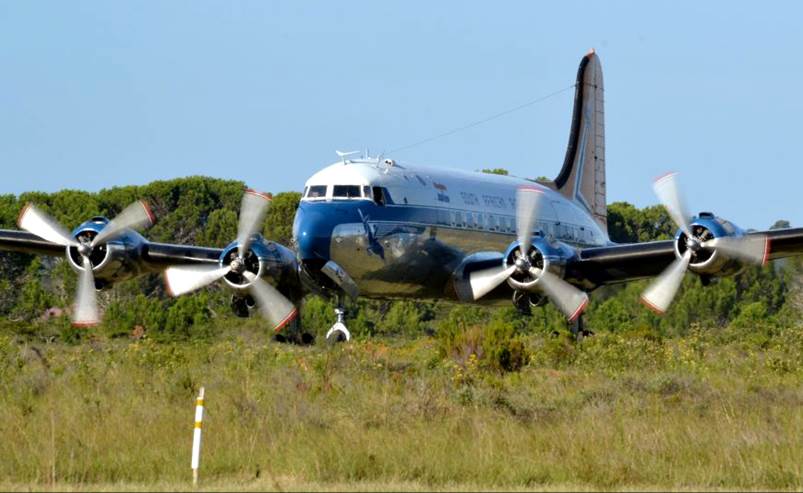 A blue and white airplane with propellers

Description automatically generated