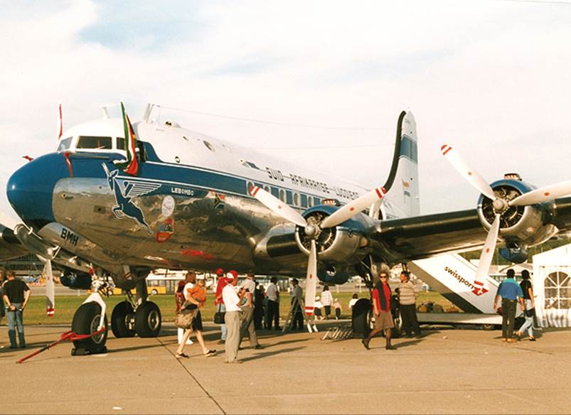 A group of people standing next to an airplane

Description automatically generated