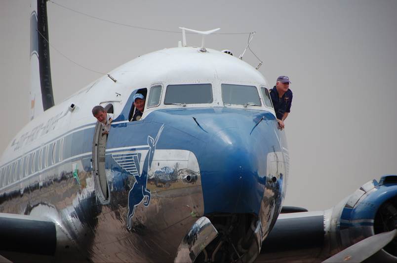 A group of people standing on the front of an airplane

Description automatically generated