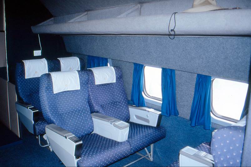 A blue and white seats in a plane

Description automatically generated