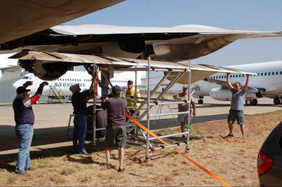 A group of men working on an airplane

Description automatically generated