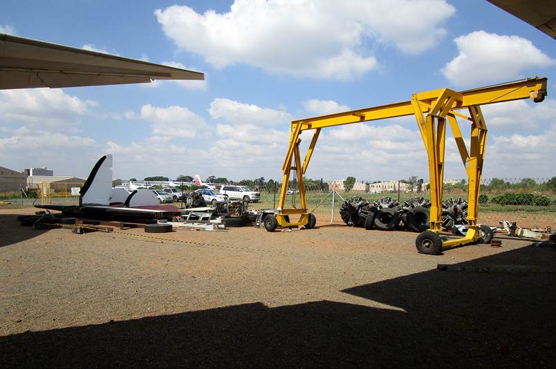 A yellow crane in a yard

Description automatically generated