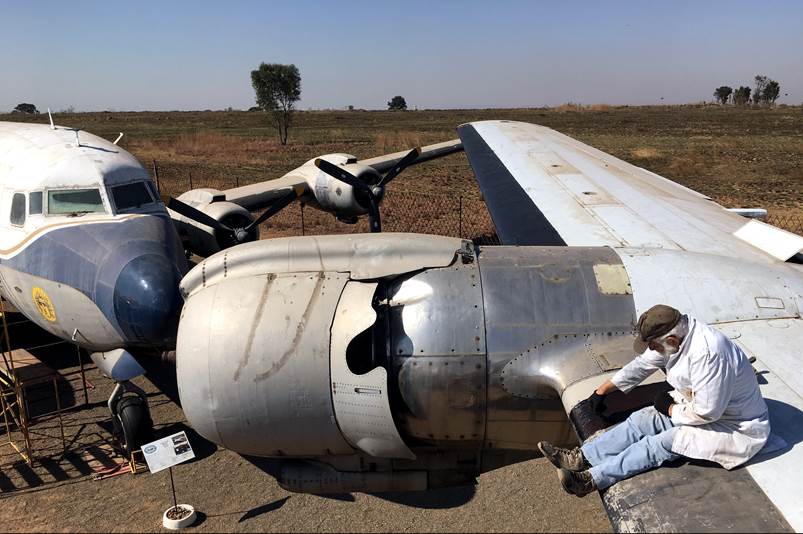 A person sitting on the wing of an airplane

Description automatically generated