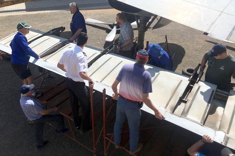 A group of men standing next to an airplane

Description automatically generated