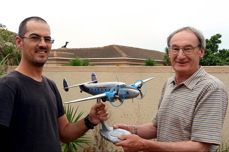 A person holding a model airplane

Description automatically generated