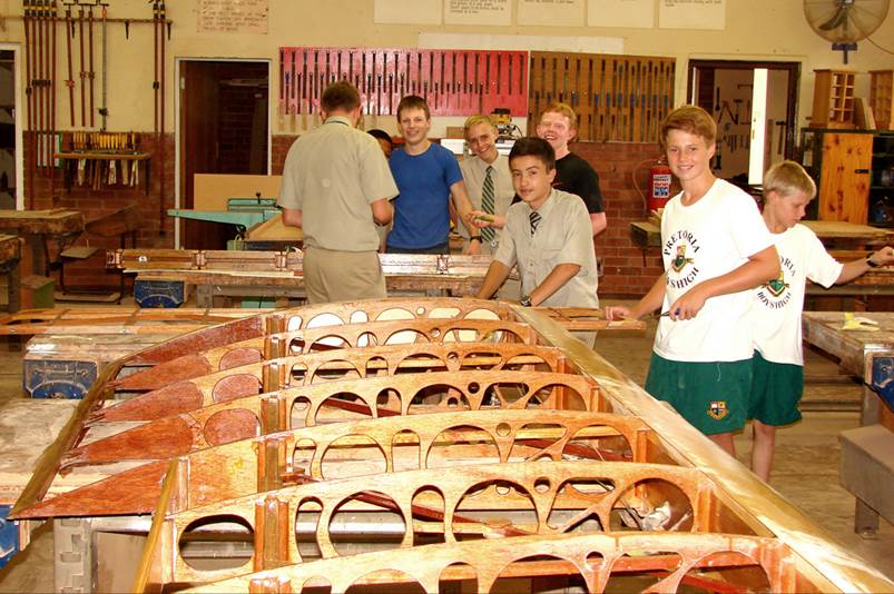 A group of people standing around a wooden structure

Description automatically generated