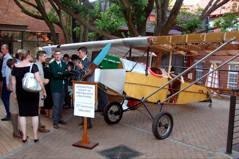 A group of people standing around a small airplane

Description automatically generated