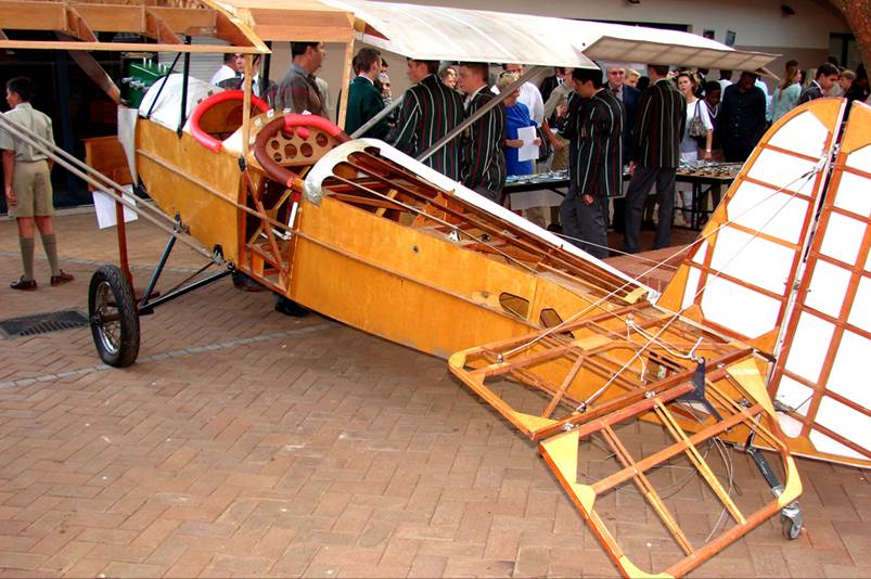 A wooden airplane with people around it

Description automatically generated