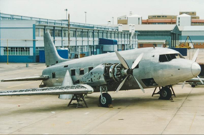 A silver airplane with propeller

Description automatically generated