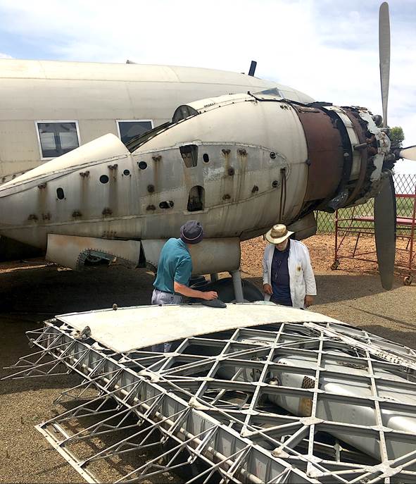 Two men standing next to an airplane

Description automatically generated