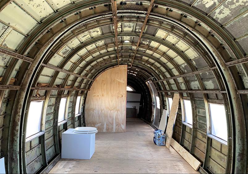 Inside a plane's interior with a wood floor

Description automatically generated with medium confidence