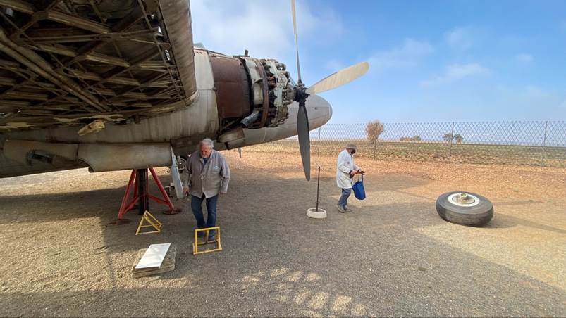 A person standing next to a propeller on a plane

Description automatically generated