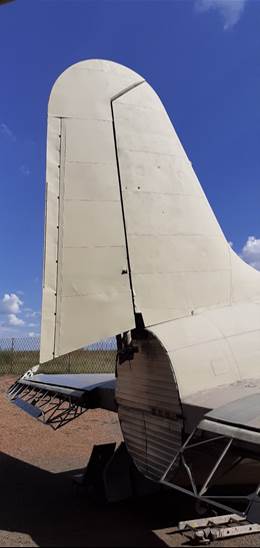 A white airplane wing with blue sky and clouds

Description automatically generated