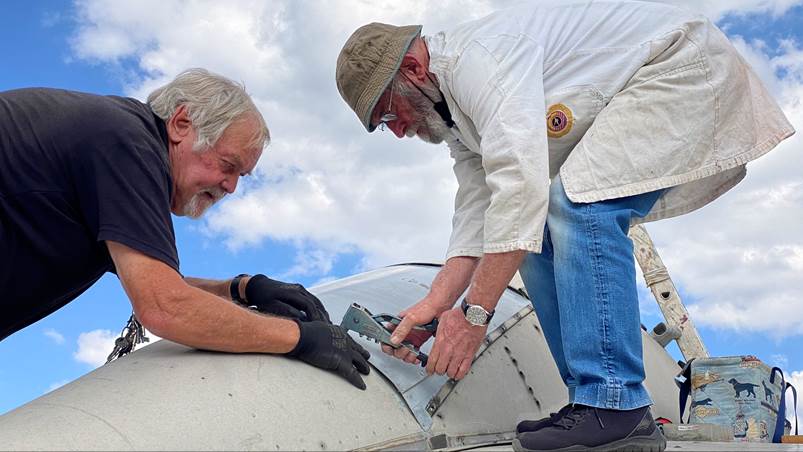 A few men working on a plane

Description automatically generated