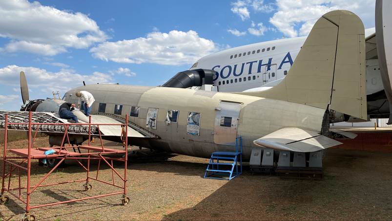 A person standing next to an airplane

Description automatically generated