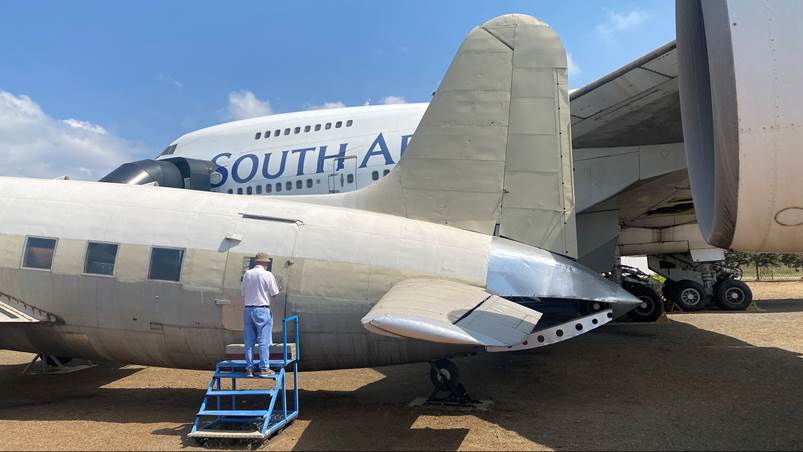 A person standing on a ladder next to an airplane

Description automatically generated