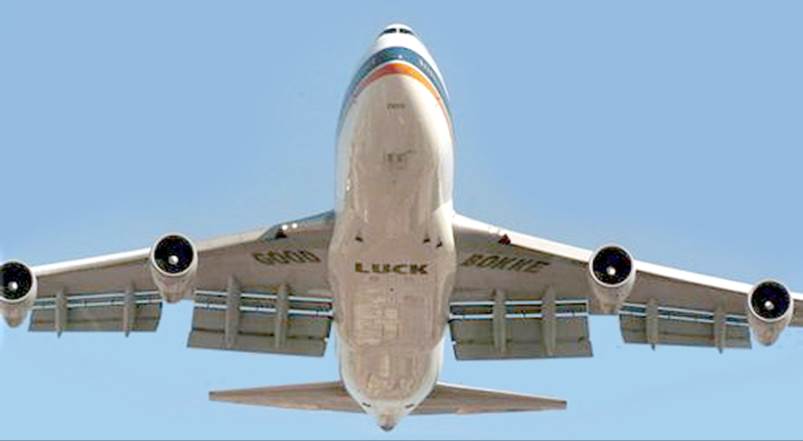 A large passenger jet flying through a blue sky

Description automatically generated