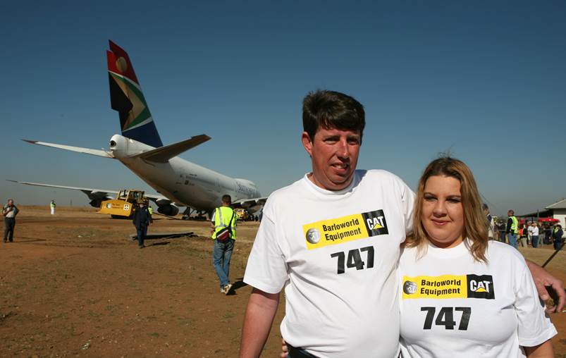 A person and person standing in front of an airplane

Description automatically generated