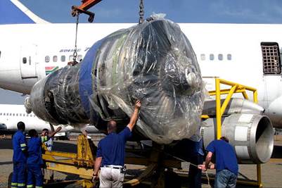 A group of men lifting a large piece of plastic

Description automatically generated