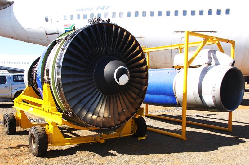 A jet engine on a yellow cart

Description automatically generated