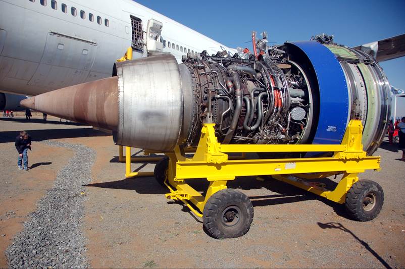 A jet engine on a yellow cart

Description automatically generated