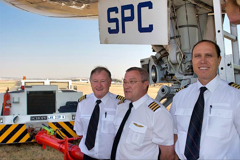 A group of men in uniform standing in front of an airplane

Description automatically generated