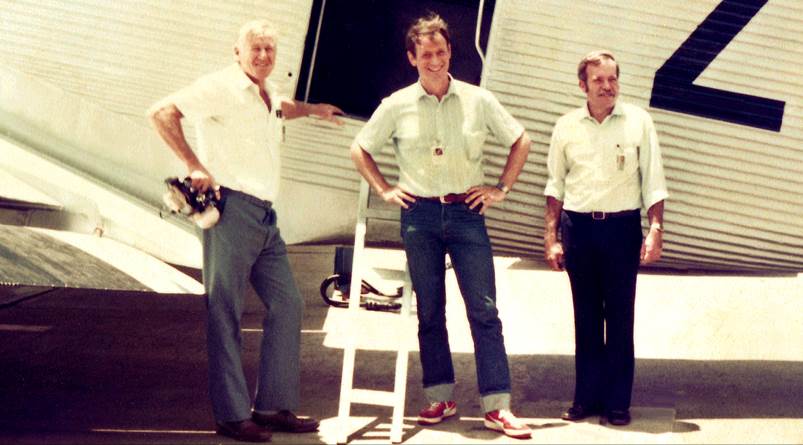 A group of men standing in front of a plane

Description automatically generated