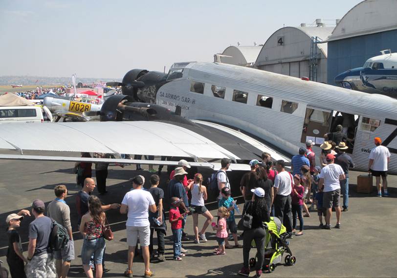 A group of people standing around an airplane

Description automatically generated