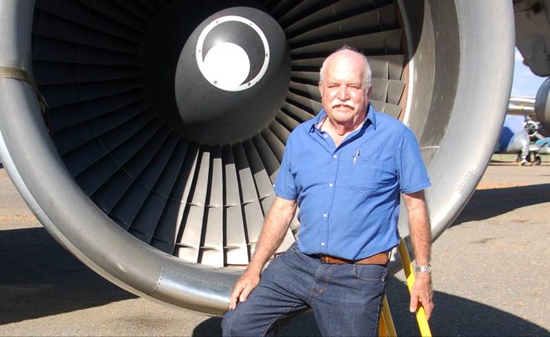 A person standing next to a jet engine

Description automatically generated