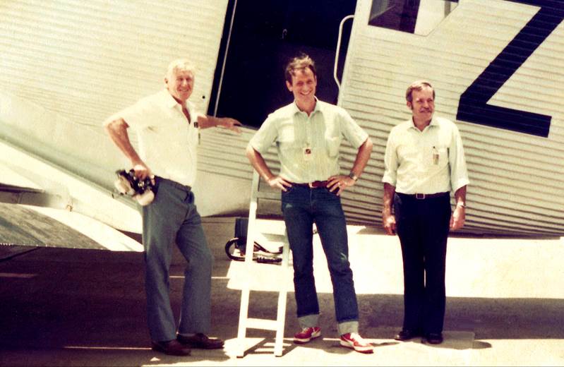 A group of men standing in front of a plane

Description automatically generated