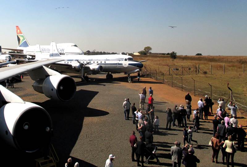 A group of people standing around airplanes

Description automatically generated