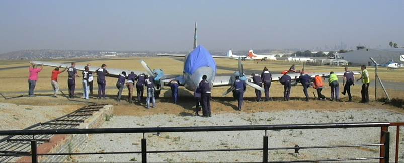 A group of people standing next to a plane

Description automatically generated