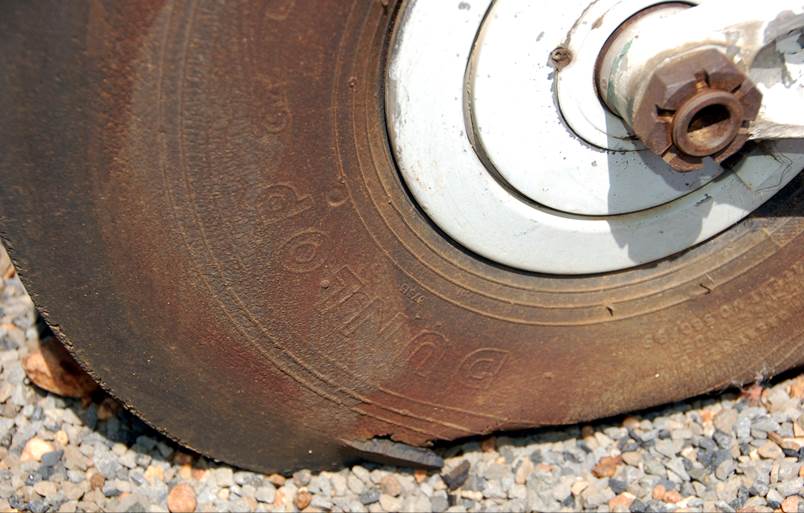 A close-up of a rusty wheel

Description automatically generated