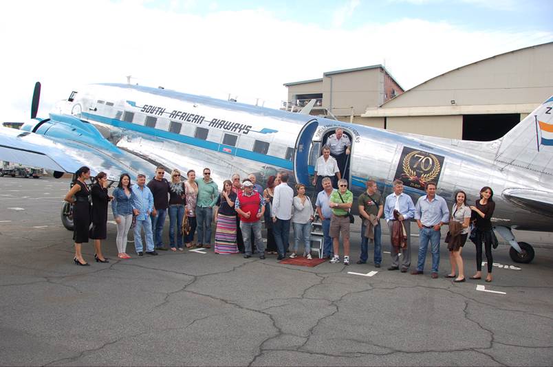 A group of people standing in front of an airplane

Description automatically generated