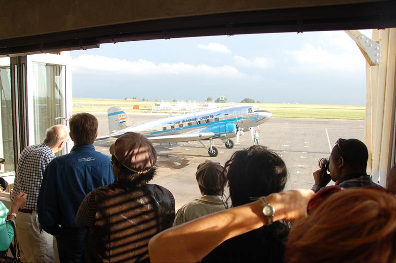 People looking out a window at an airplane

Description automatically generated