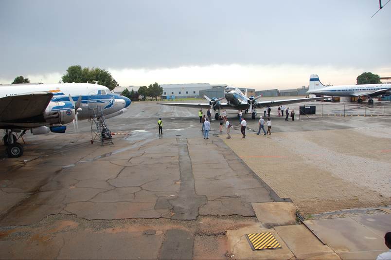 A group of people standing next to an airplane

Description automatically generated