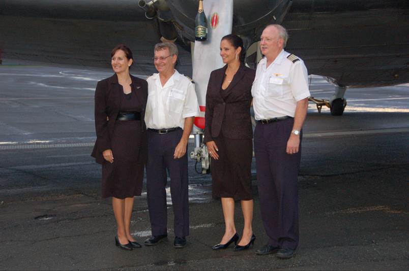 A group of people standing in front of an airplane

Description automatically generated