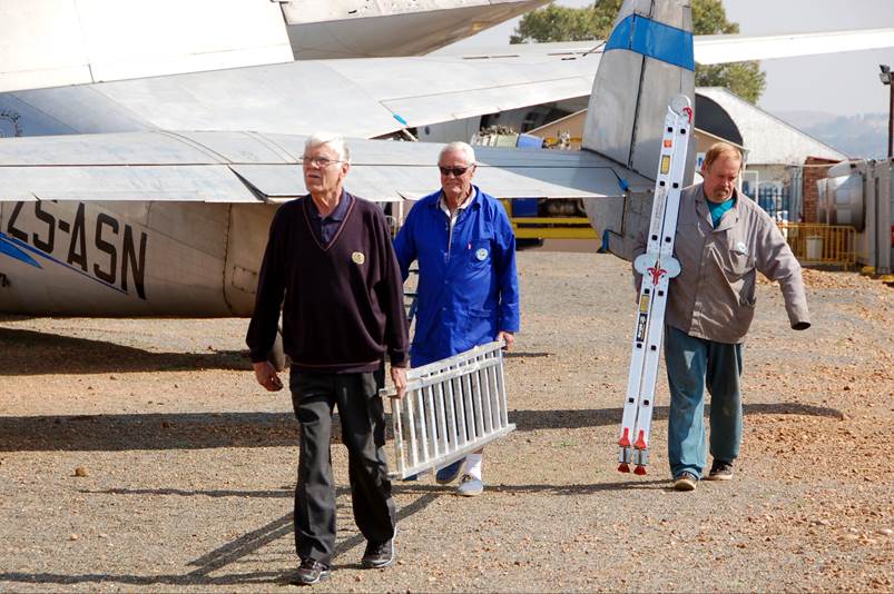 A group of people walking by an airplane

Description automatically generated